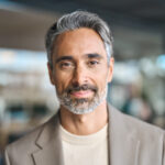 Happy middle aged mature business man looking at camera in office, headshot